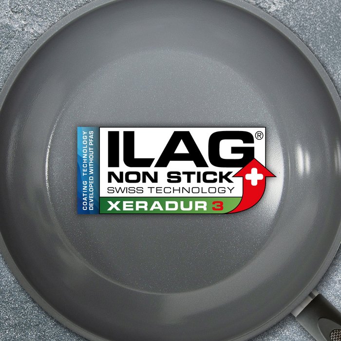 Grey glossy inside of a frying pan - ILAG logo with dark green shaded Xeradur 3 lettering in the center and on the left hand side an extra labeling "PFAS-FREE" in blue